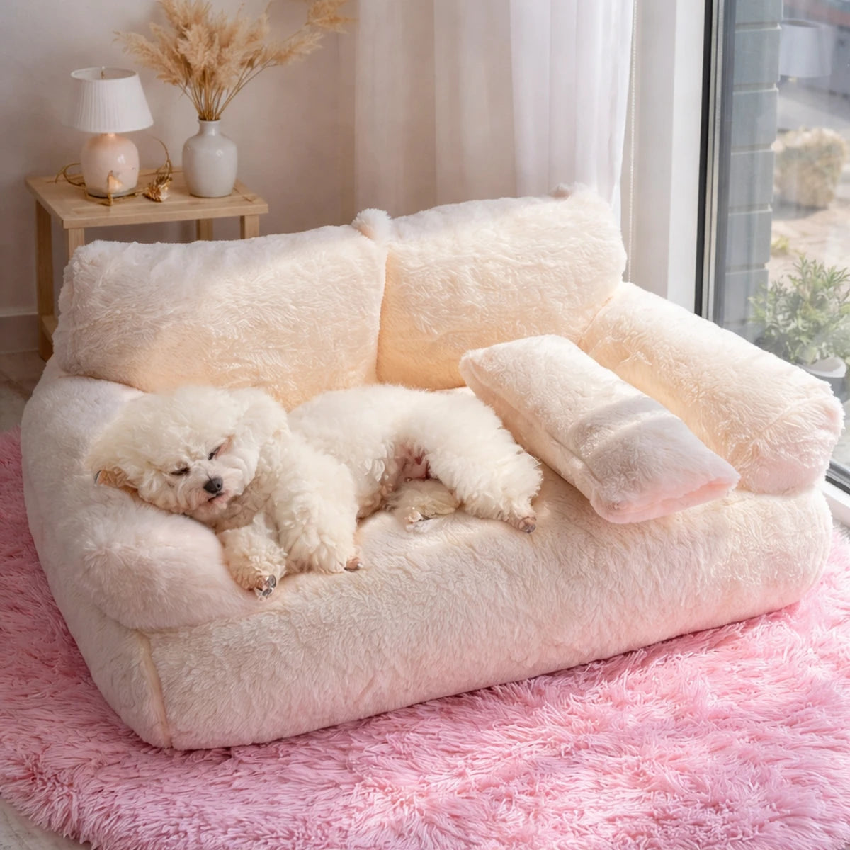 Petit chien blanc dormant sur un canapé en peluche clair dans un salon lumineux