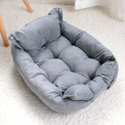 Coussin pour chien gris avec rebords épais et dossier, posé sur un tapis clair en intérieur